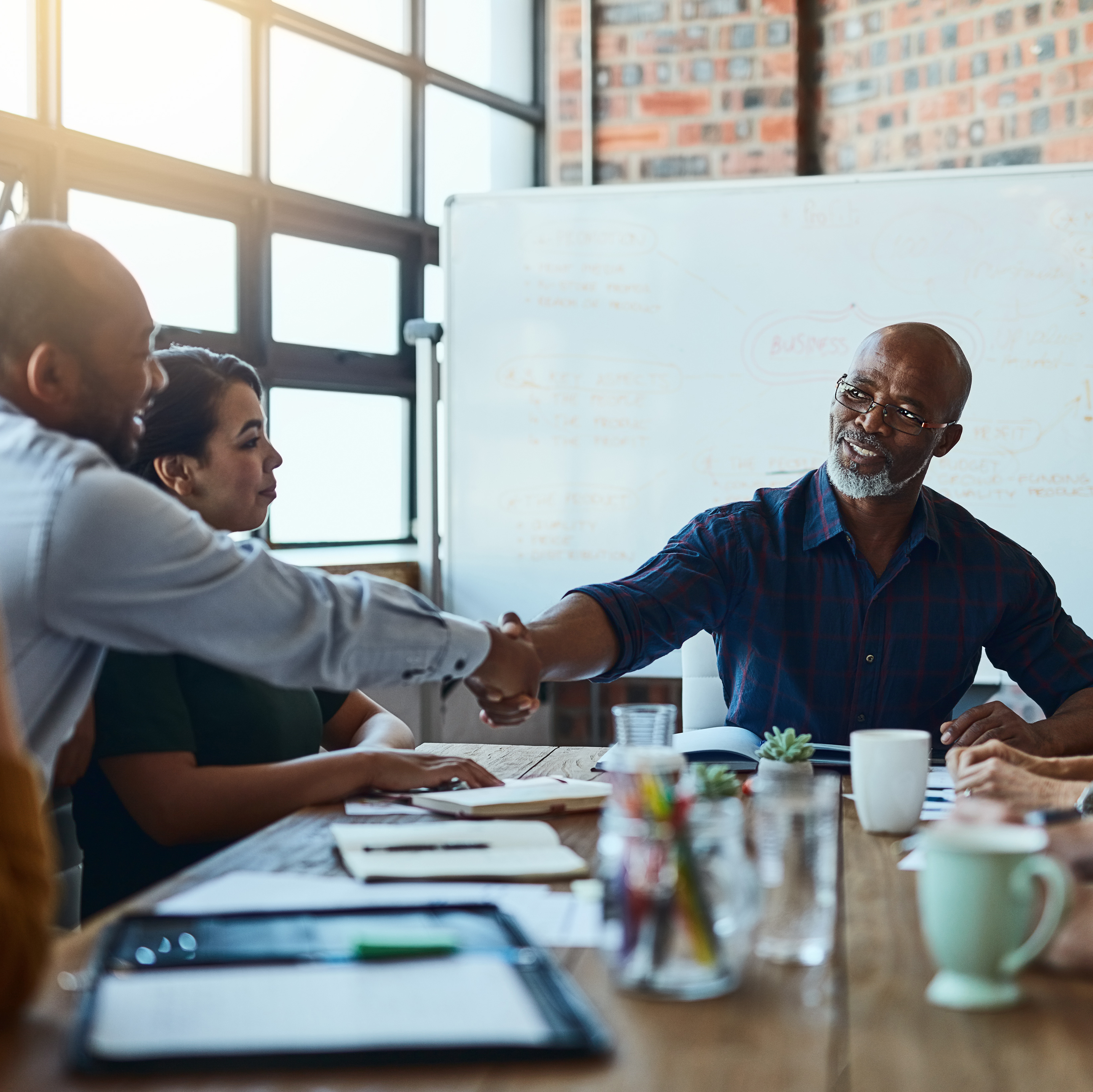 business-professionals-shaking-hands-at-a-table.png