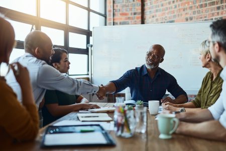 business-professionals-shaking-hands-at-a-table.png