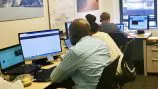 a work space with 3 people working on computers